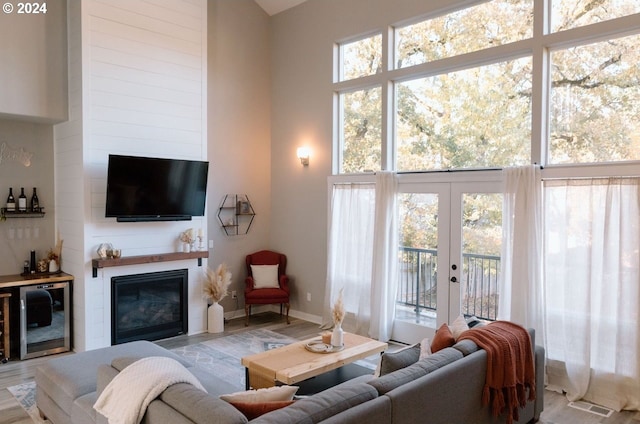 living room with a high ceiling, light hardwood / wood-style flooring, and a fireplace