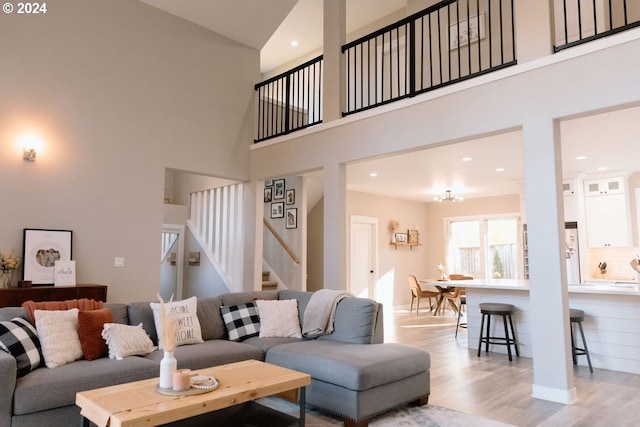 living room with light hardwood / wood-style flooring and a towering ceiling