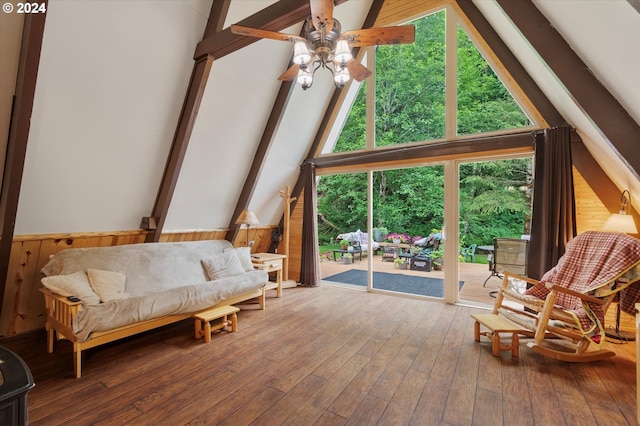 living room with ceiling fan, vaulted ceiling with beams, hardwood / wood-style floors, and wooden walls