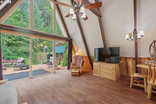 interior space featuring beamed ceiling, wooden walls, ceiling fan with notable chandelier, and hardwood / wood-style flooring