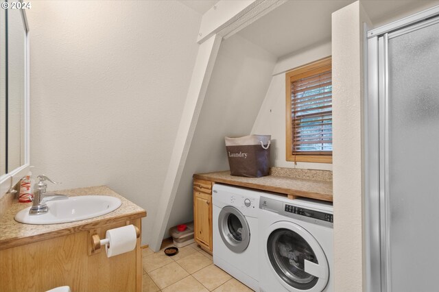 laundry room with sink, washer and dryer, and light tile patterned flooring