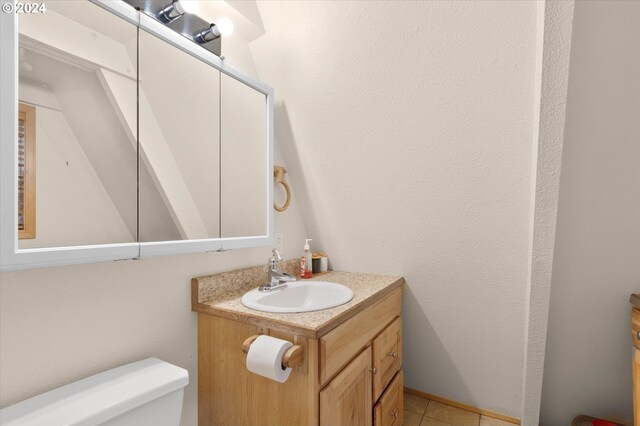 bathroom featuring tile patterned flooring, vanity, and toilet