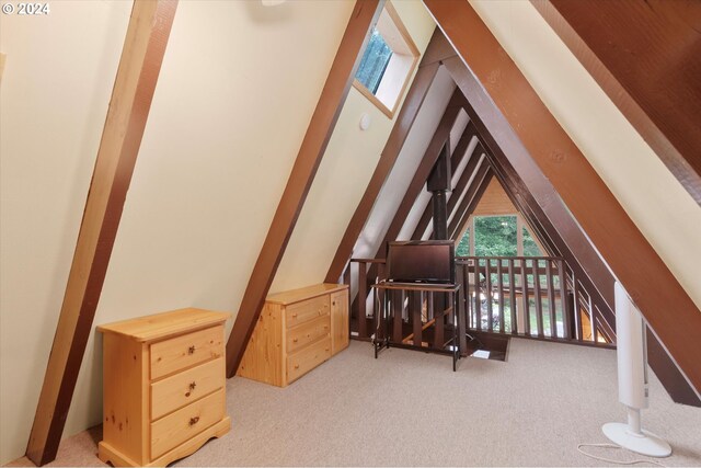 living area with vaulted ceiling and light colored carpet