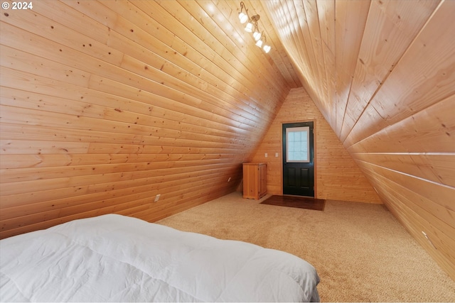 carpeted bedroom with wooden walls, wooden ceiling, and vaulted ceiling