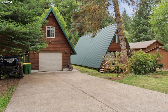 view of side of home with a garage, metal roof, driveway, and an outdoor structure