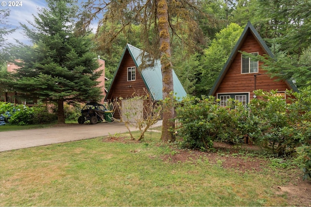 view of home's exterior with a yard, metal roof, and driveway