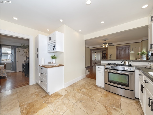 kitchen featuring kitchen peninsula, stainless steel range, ceiling fan, light hardwood / wood-style flooring, and white cabinetry