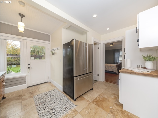 kitchen featuring white cabinets, stainless steel fridge, and pendant lighting