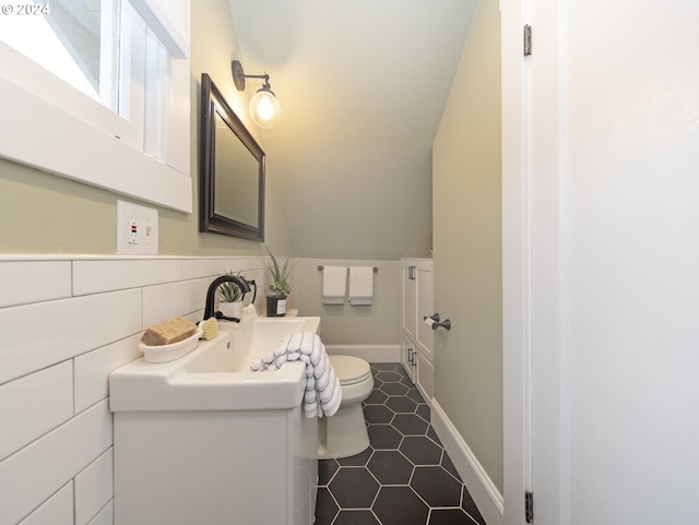 bathroom featuring tasteful backsplash, tile patterned flooring, vanity, and toilet