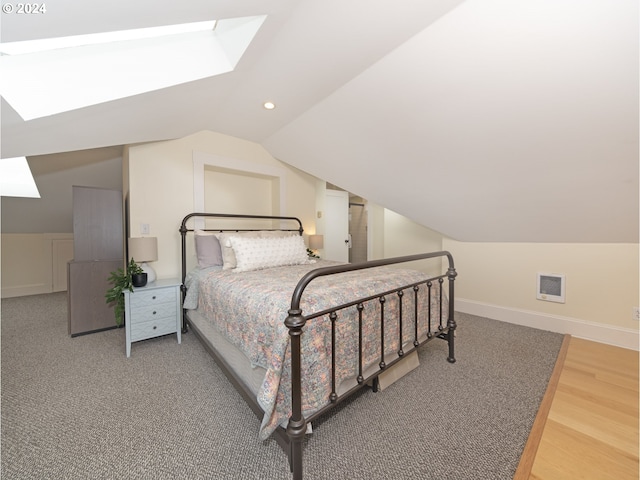 bedroom featuring hardwood / wood-style floors and vaulted ceiling with skylight