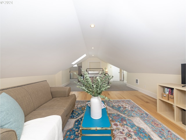 interior space with light wood-type flooring and vaulted ceiling with skylight