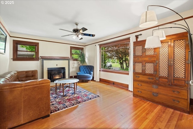 1718 23rd Ave, Forest Grove, OR 97116 - living area featuring wood finished floors, a ceiling fan, a lit fireplace, and baseboards