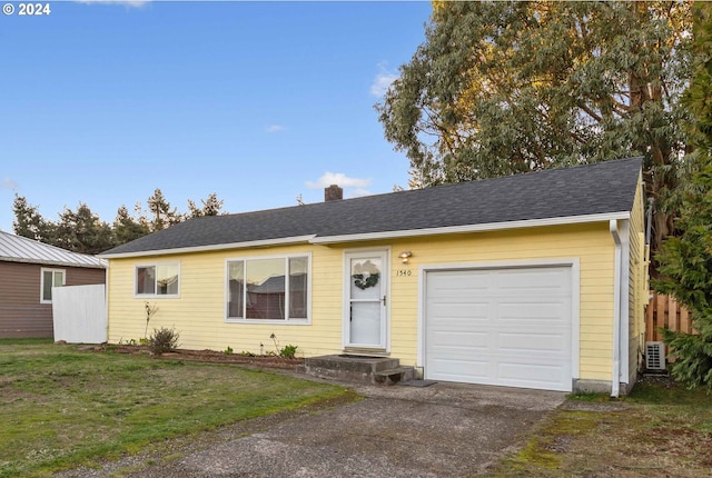 ranch-style house with a front yard and a garage