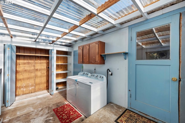 clothes washing area featuring cabinets and separate washer and dryer