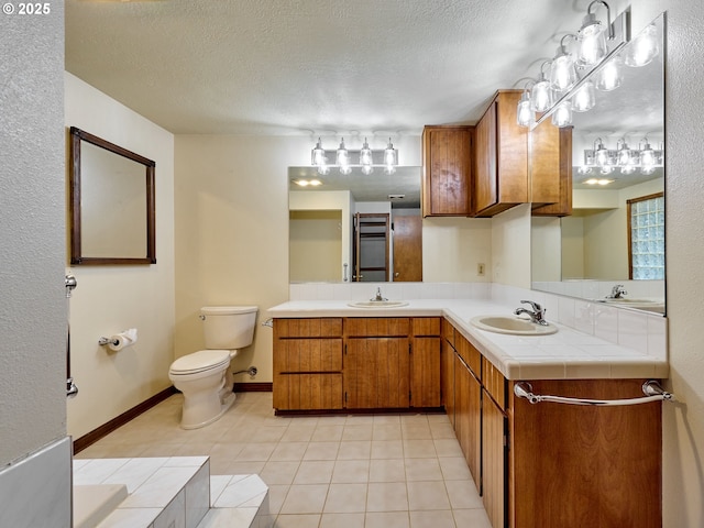 bathroom featuring a textured ceiling, tile patterned flooring, and vanity