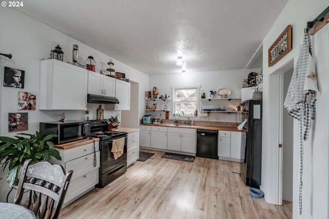 kitchen featuring white cabinetry, light hardwood / wood-style flooring, black appliances, wood counters, and sink