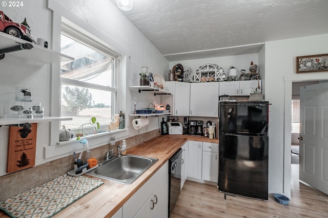 kitchen with black appliances, wooden counters, and white cabinetry