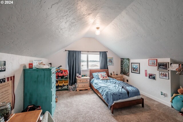 bedroom featuring vaulted ceiling, carpet, and a textured ceiling