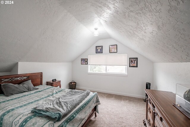 carpeted bedroom with a textured ceiling and lofted ceiling