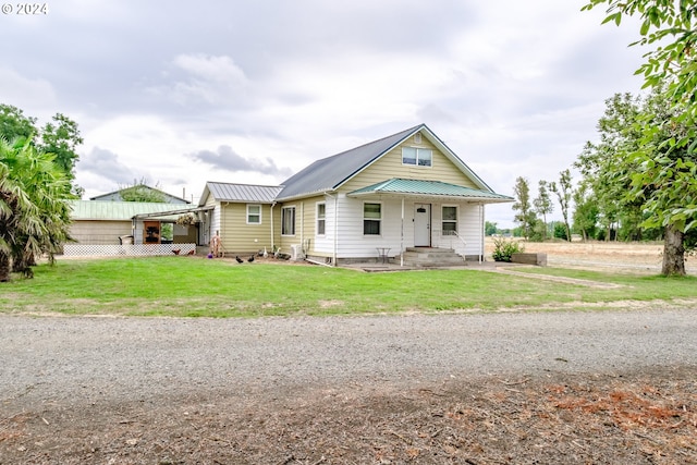 bungalow with a porch, a standing seam roof, metal roof, and a front lawn