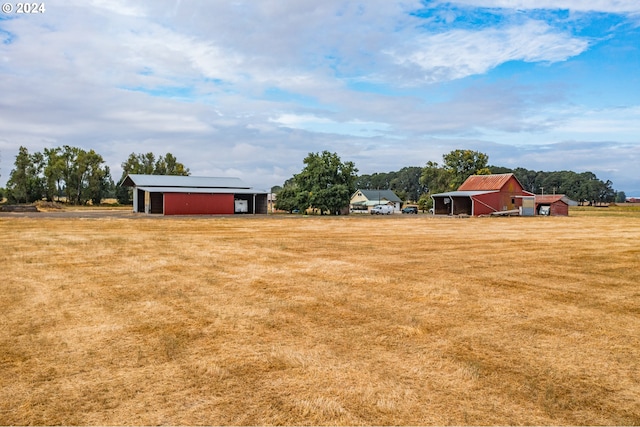 view of yard featuring an outbuilding, a pole building, and a detached garage