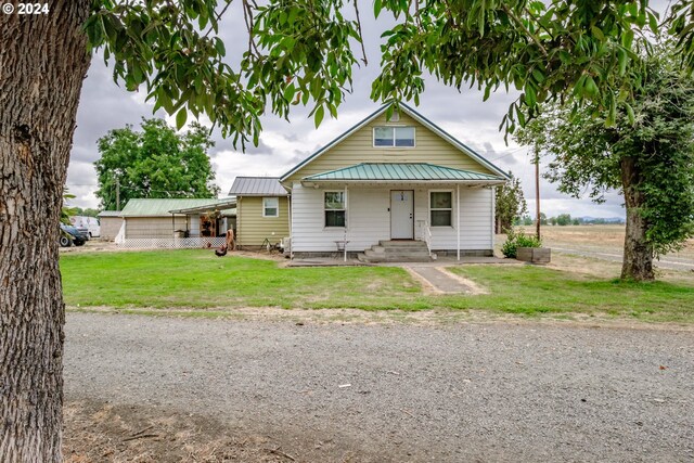 bungalow with covered porch and a front lawn