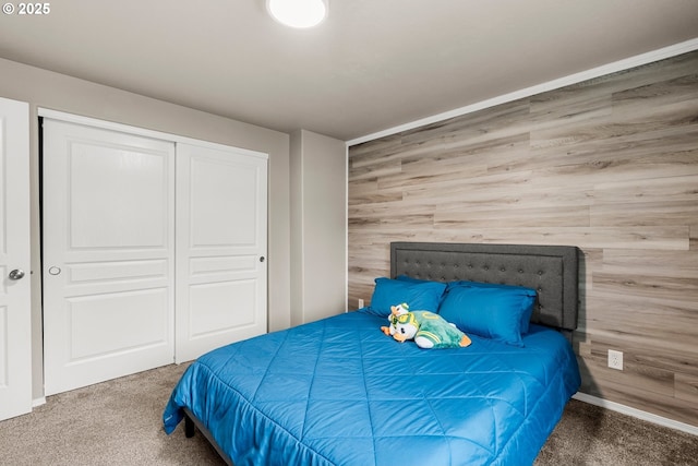 bedroom featuring a closet, carpet, and wood walls