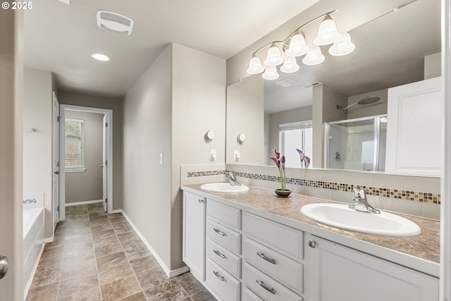 bathroom with vanity, backsplash, plus walk in shower, and a healthy amount of sunlight