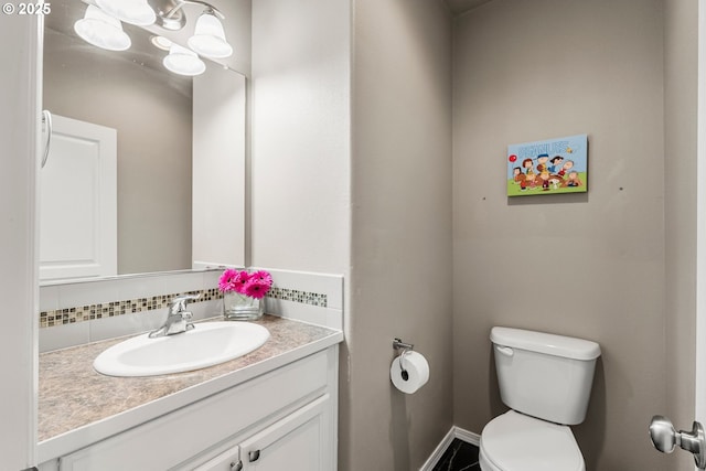 bathroom featuring vanity, backsplash, and toilet