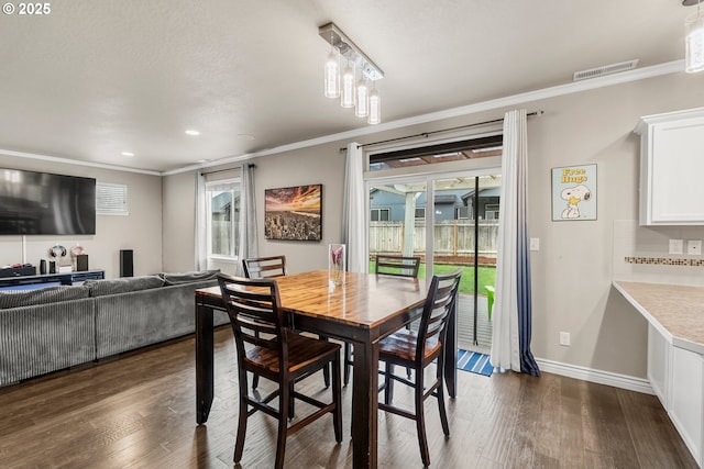 dining area with crown molding and dark hardwood / wood-style floors