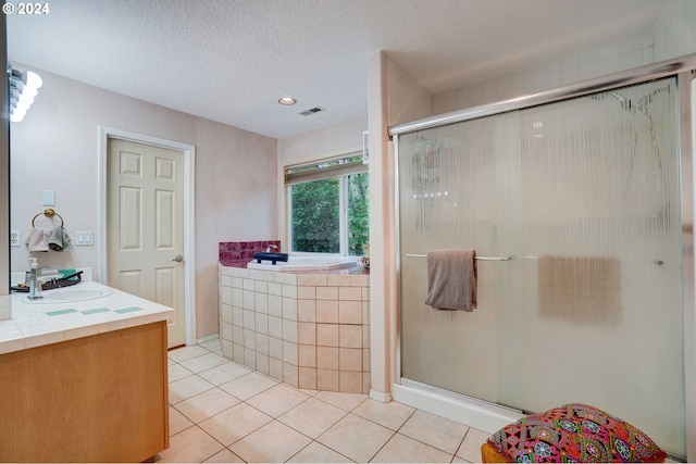 bathroom with vanity, a textured ceiling, shower with separate bathtub, and tile patterned flooring