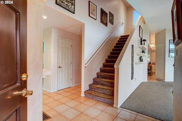 foyer entrance featuring light colored carpet