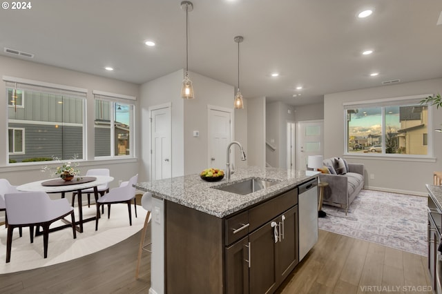 kitchen featuring dishwasher, sink, hanging light fixtures, dark hardwood / wood-style floors, and dark brown cabinets