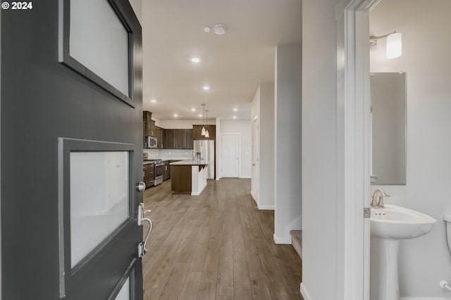 hallway with light hardwood / wood-style floors