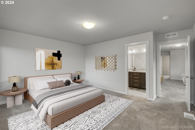 carpeted bedroom featuring sink and ensuite bathroom