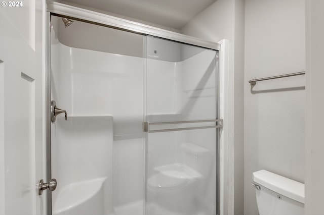 bathroom featuring an enclosed shower and toilet