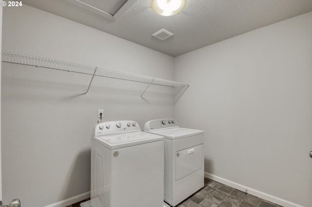 washroom featuring independent washer and dryer and a textured ceiling