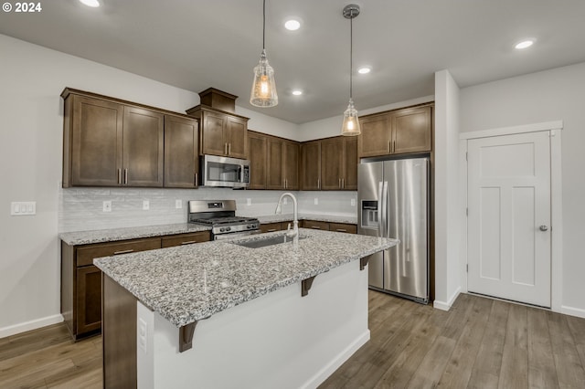 kitchen with a breakfast bar, backsplash, sink, and stainless steel appliances