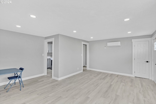 interior space featuring a wall mounted air conditioner and light wood-type flooring