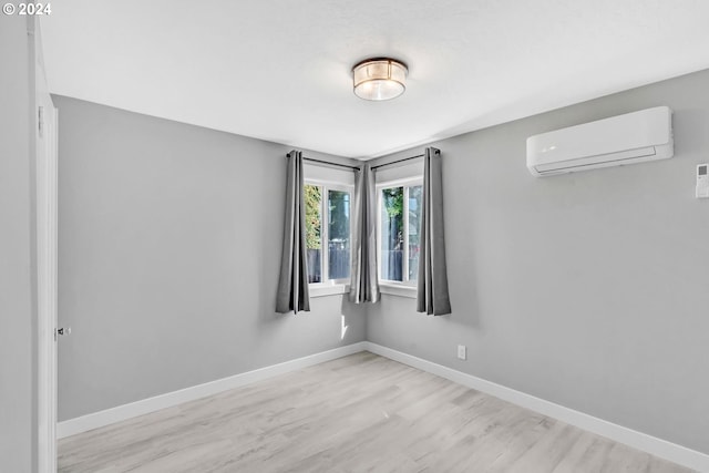 empty room featuring light hardwood / wood-style floors and a wall mounted AC