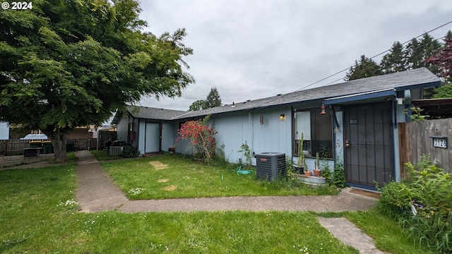 single story home featuring a front lawn and central AC unit