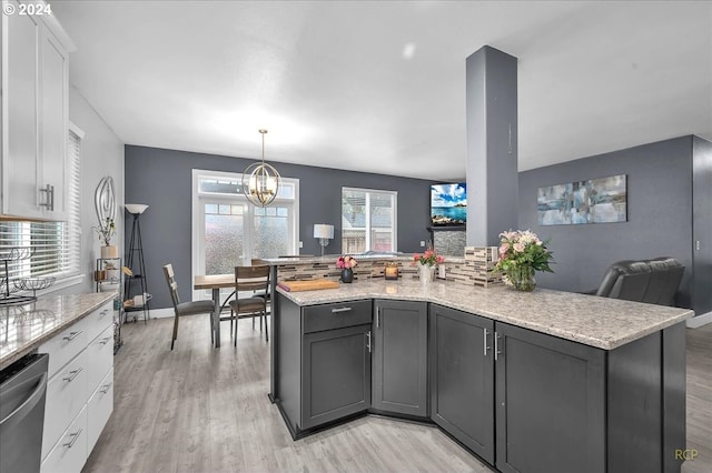 kitchen featuring white cabinets, dishwasher, light stone counters, and light hardwood / wood-style floors