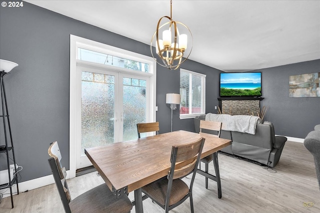 dining area featuring french doors, a notable chandelier, and light wood-type flooring