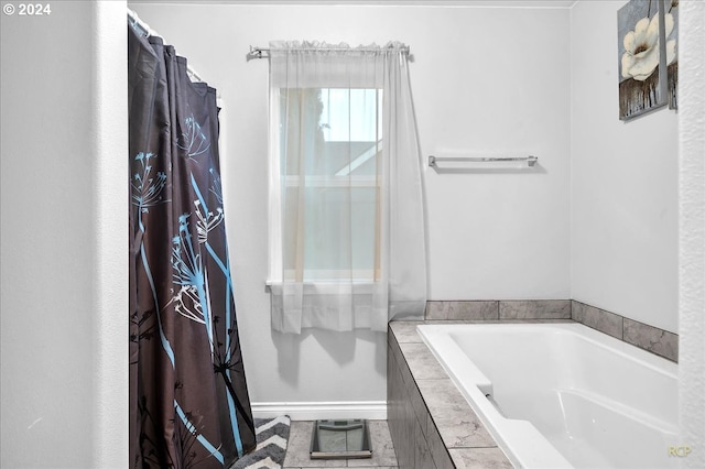 bathroom with tile patterned floors and a relaxing tiled tub