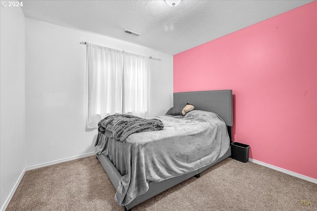 carpeted bedroom featuring a textured ceiling