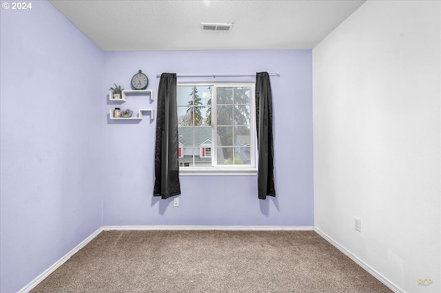 carpeted spare room with a textured ceiling