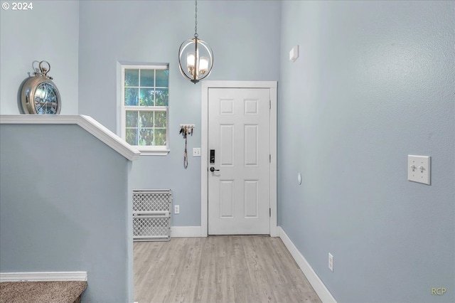 foyer with light hardwood / wood-style flooring and a notable chandelier