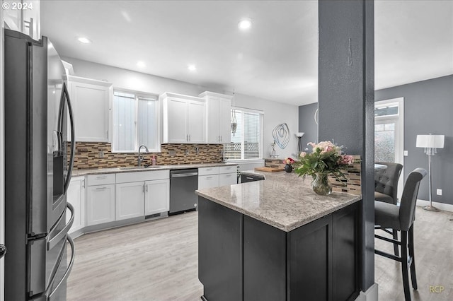 kitchen featuring light stone countertops, white cabinetry, appliances with stainless steel finishes, and sink