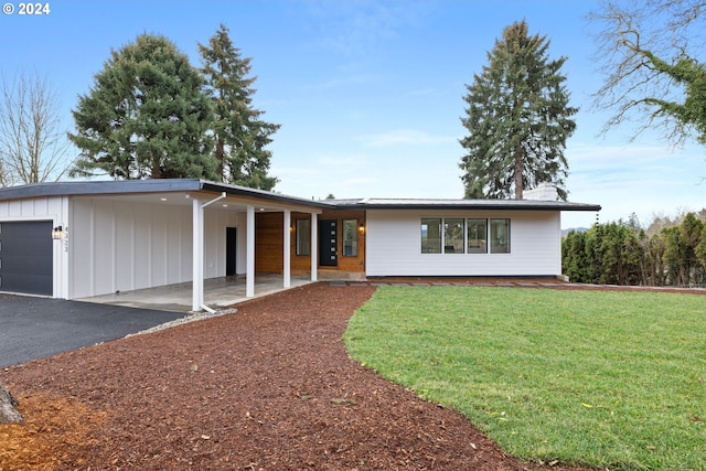 ranch-style home featuring a front yard, a garage, and a carport