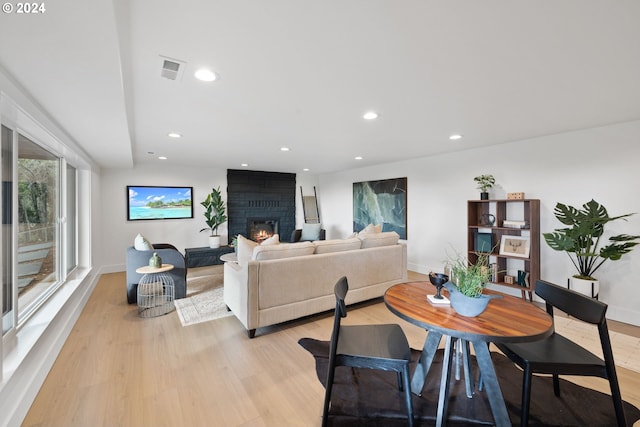 dining room with a large fireplace and light hardwood / wood-style flooring